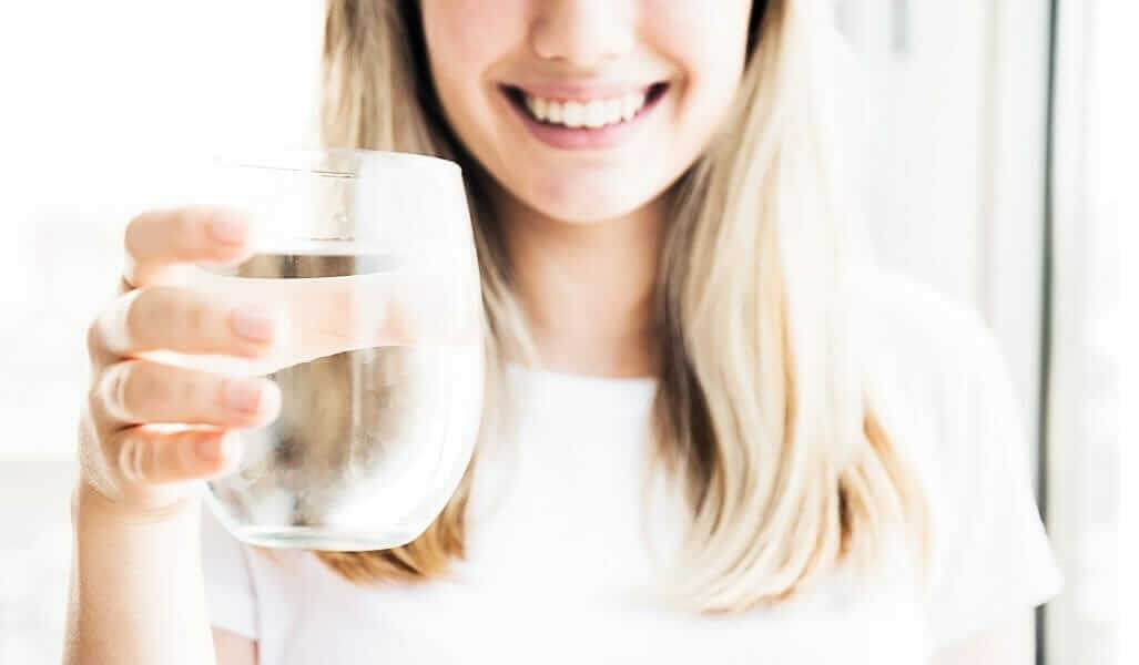 Lächelnde Frau mit einem Glas in der Hand