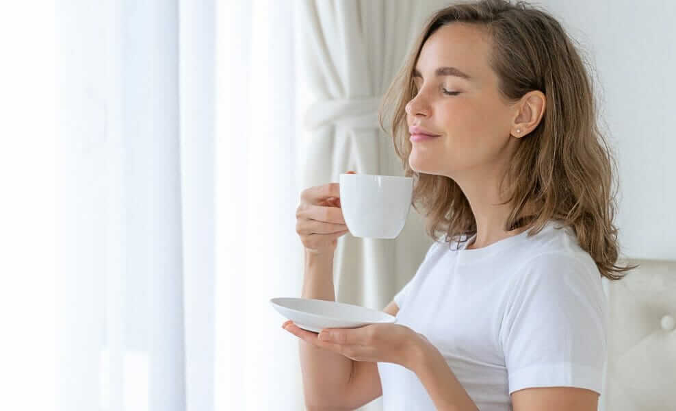 Frau genießt eine Tasse Tee mit frisch gefiltertem Wasser