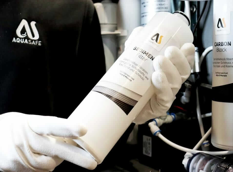 Wartungspaket AS-X Filterwechsel - Servicemitarbeiter mit Sediment-Filter in der Hand